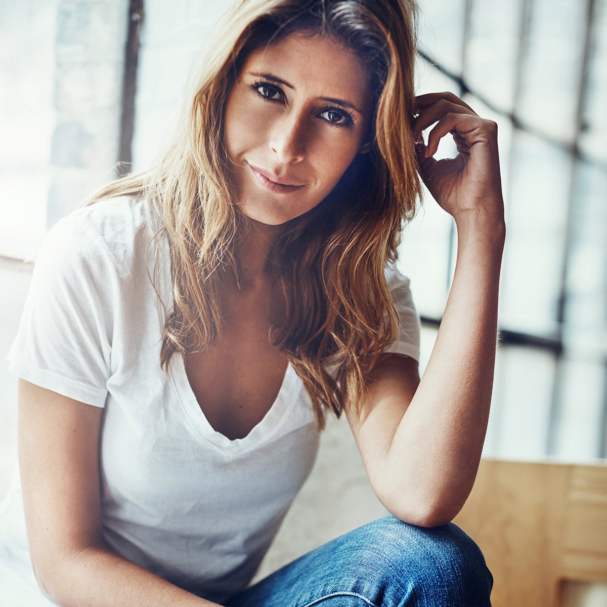 juvederm volux patient model resting her elbow on her knee while smiling at camera